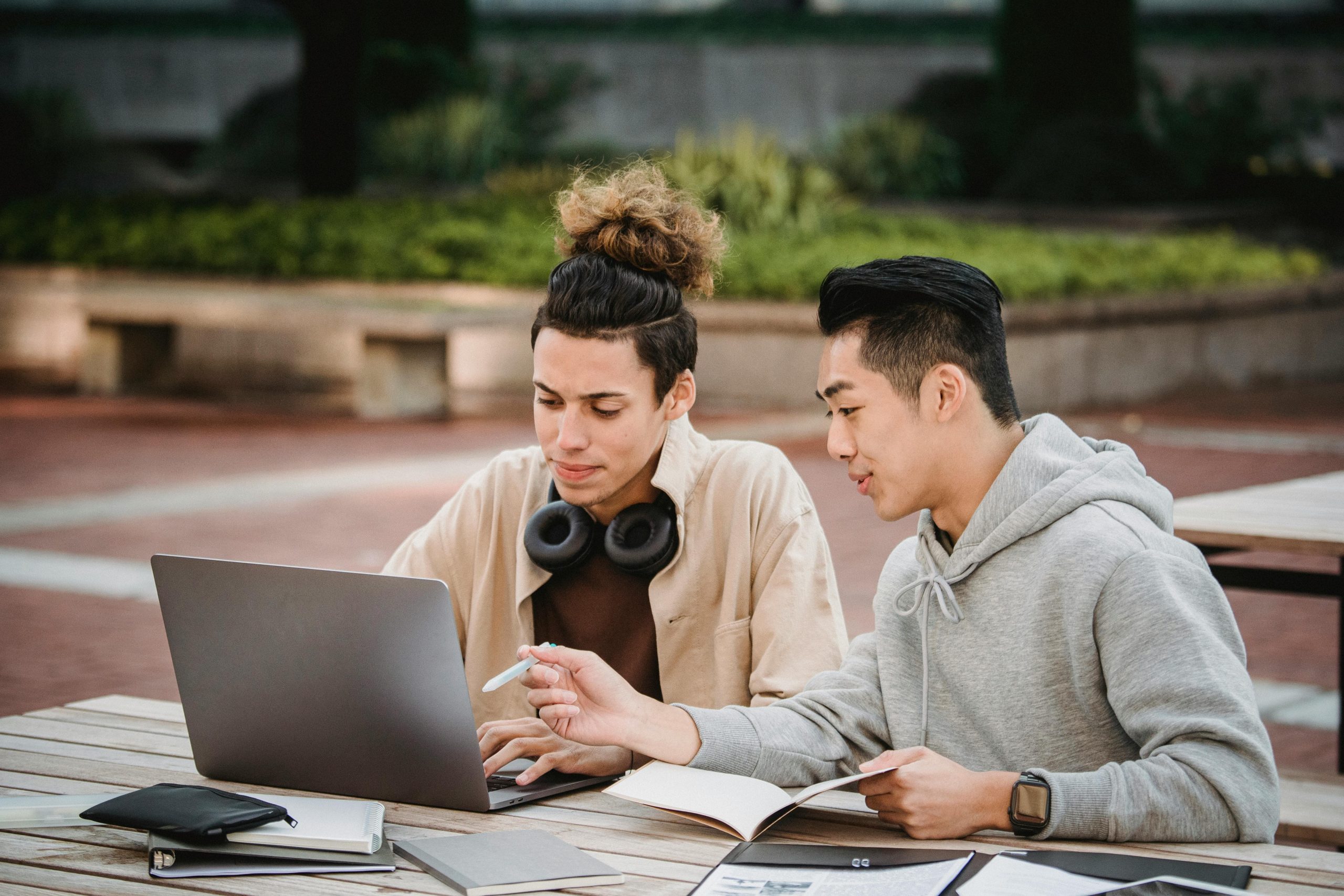 College students studying together outdoors with a laptop