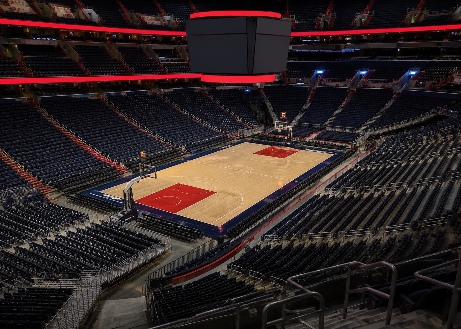 Empty indoor basketball arena with red and blue court accents