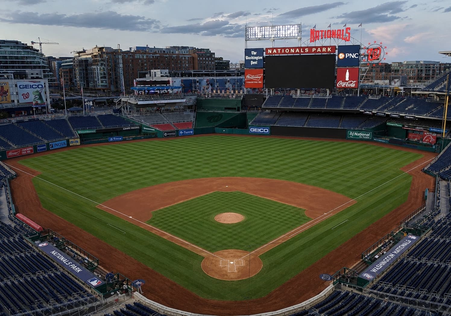 Empty baseball stadium at dusk with city skyline views